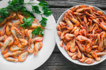 on a wooden background, white plate with shrimps
