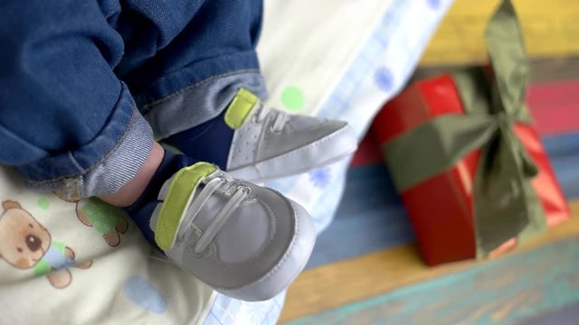Feet of baby in sneakers. Little child wearing shoes. Born to be stylish.