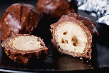 Sweets and desserts, round chocolate sweets with nut cream filling , macro