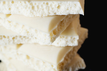 sweets and desserts, macro food, milky white  porous chocolate  on a dark background