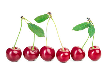 ripe juicy cherry berries with leaves on a white table
