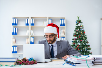 Young businessman celebrating christmas in the office