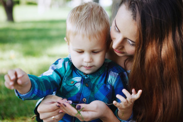 Young mother with little son having fun playing in the Park