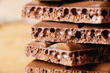 sweets and desserts, macro food, milky porous chocolate with coffee beans on a brown background