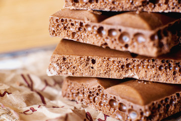 sweets and desserts, macro food, milky porous chocolate with coffee beans on a brown background