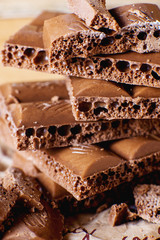 sweets and desserts, macro food, milky porous chocolate with coffee beans on a brown background