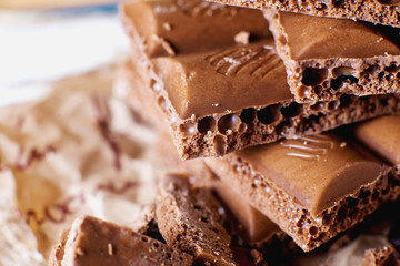 sweets and desserts, macro food, milky porous chocolate with coffee beans on a brown background