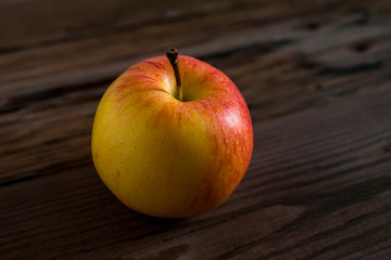 Ripe red apple on rustic dark wooden table