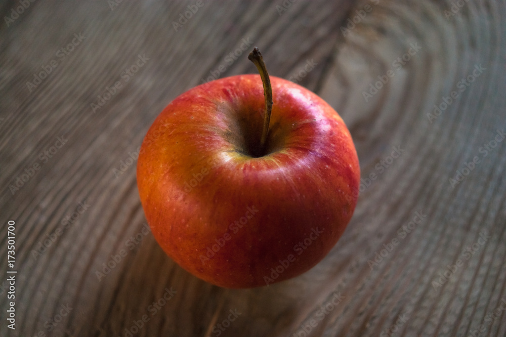 Wall mural ripe red apple on rustic dark wooden table