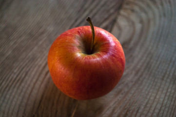 Ripe red apple on rustic dark wooden table