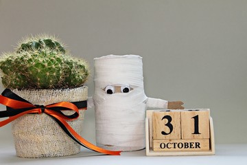 Halloween, celebration or holiday background concept : Halloween paper craft, cube calendar and cactus on gray background