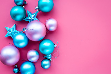 Christmas toys pattern. Pink and blue balls and stars on pink background top view copyspace