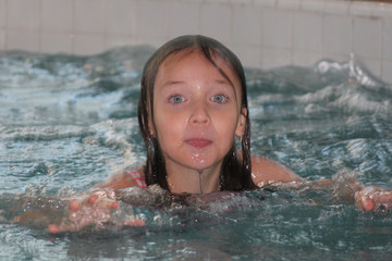 Young girl-child, playing in and, having fun in a swimming pool.