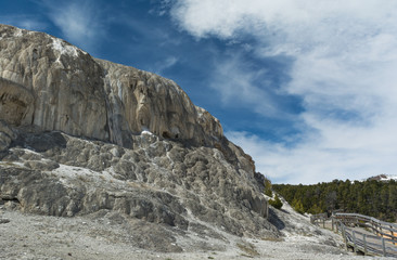 Fototapeta na wymiar Mineral rock cliff with walkway at Mammoth Hot Springs