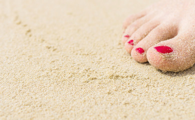 Fototapeta na wymiar Woman's feet covered in sand. Selective focus. Travel image for background.