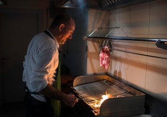 A chef cooking meat in the barbeque