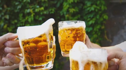 Slow motion beer mug toast with spilling beer