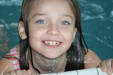 Young girl-child, playing in and, having fun in a swimming pool.

