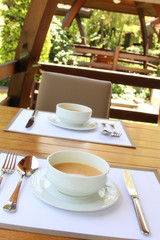 Two plates of hot soup on a summer terrace