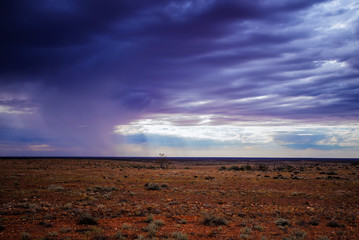 Storm in the desert. Rain in distance on red desert soil in the outback, Australia.