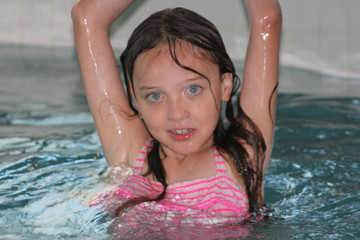 Young girl-child, playing in and, having fun in a swimming pool.

