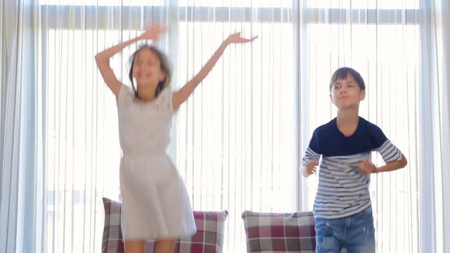 The children are having fun. The boy and the girl are having fun. The children are dancing. The children are jumping.