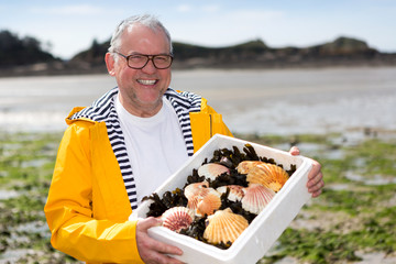 Portrait of a senior fisherman with scallop he just  collect