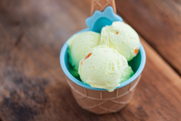 Vanilla ice cream with a taste of melon in a bowl on old wooden table