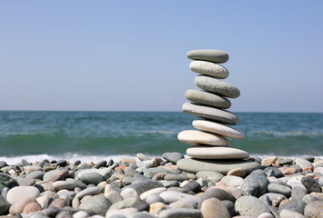 Fototapeta na wymiar folded pyramid of smooth stones on the seashore