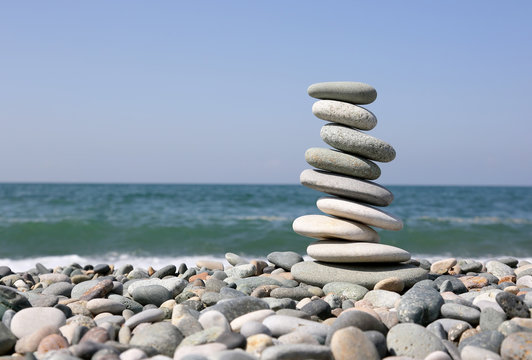 Folded Pyramid Of Smooth Stones On The Seashore