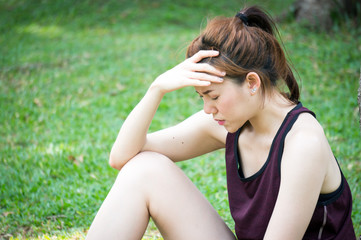 Naklejka na ściany i meble Asian sport woman have headache after running in park outdoor
