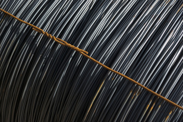 Rundstahl in Ringen im Materiallager, einzelner Ring mit diagonal verlaufendem Bindedraht, symetrie