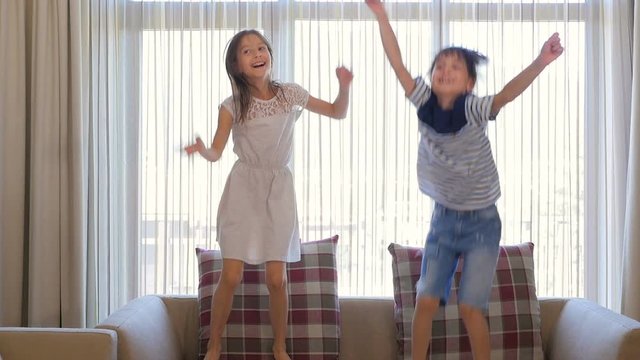 The children are having fun. The boy and the girl are having fun. The children are dancing. The children are jumping.