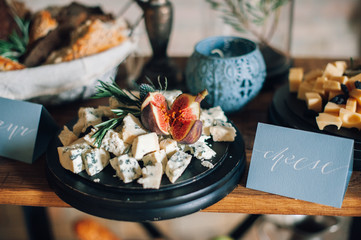 decorated tables with plates of cheese, baskets of bread, candles, candlesticks, flowers, bouquet, jam