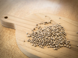 Close up Coriander seeds on wooden board. Preparation ingredient for cooking.