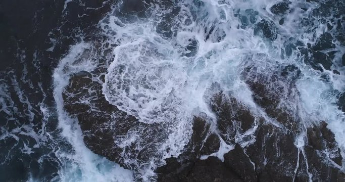 Flight over the turquoise waves that beat the rocks in Montenegro 