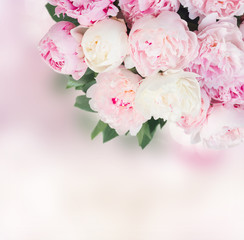Obraz na płótnie Canvas Fresh peony flowers with leaves over pink bokeh background
