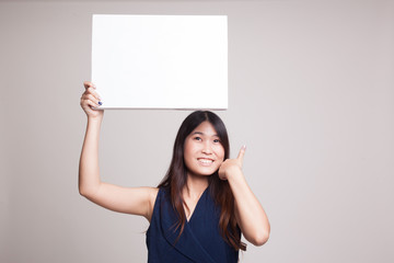 Fototapeta premium Young Asian woman show thumbs up with white blank sign.