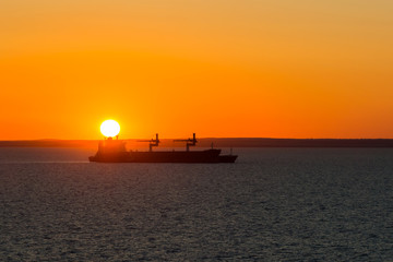 Fototapeta premium Dry cargo vessel at anchor when it sunset.