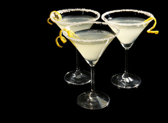 Glasses of lemon drop martini with zest on black background