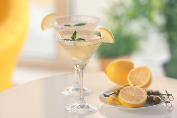 Glasses with tasty lemon drop martini cocktail on table