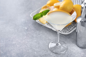 Glass with tasty lemon drop martini cocktail on table