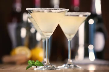 Crédence de cuisine en verre imprimé Cocktail Glasses with tasty lemon drop martini cocktail on table
