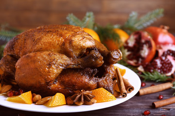 Tasty roasted turkey with slices of orange on plate