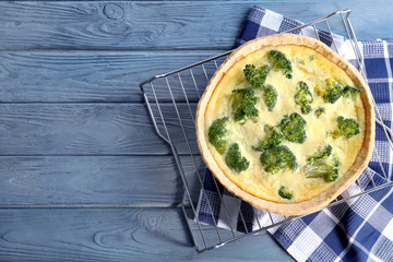 Tasty broccoli quiche on wooden table