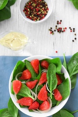 Plate of salad with spinach and grapefruit on table