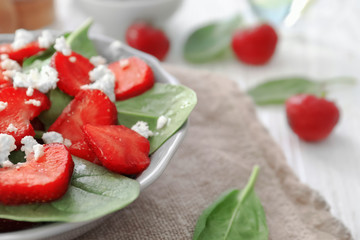 Plate of salad with spinach, strawberry and cottage cheese on table, closeup