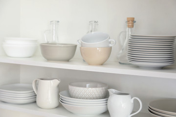 Fototapeta na wymiar Kitchen cupboard with different clean dinnerware