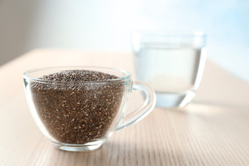 Chia seeds in glass cup on wooden table