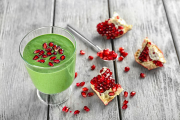 Glass of fresh green smoothie on wooden background